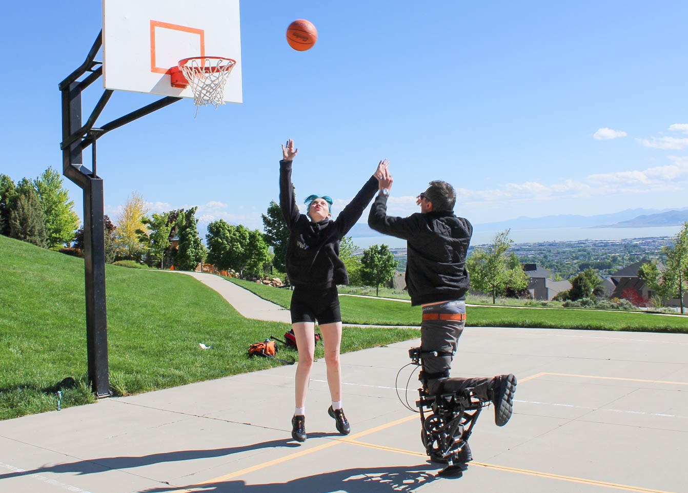 Two people using the scooter-crutch on a basketball court